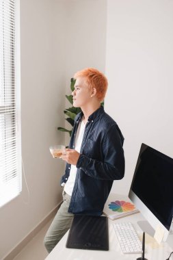 Erkek yaratıcı çalışan Resepsiyon yaratıcı ofis önünde çay bardağı ile ayakta