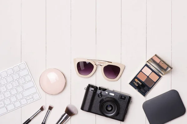 女性の化粧品とカメラとパスポートを持つテーブル上のファッションアイテム トップ ビュー — ストック写真