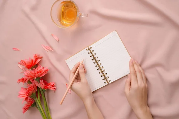 Manos Femeninas Con Escritura Lápiz Cuaderno Blanco Sobre Fondo Rosa — Foto de Stock