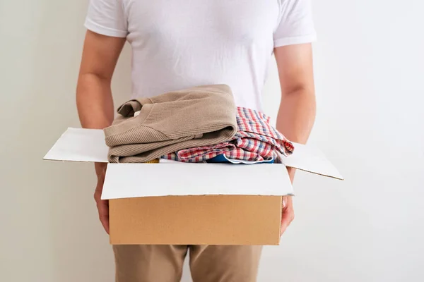 服を持っている男は箱を寄付する 寄付の考え方 — ストック写真