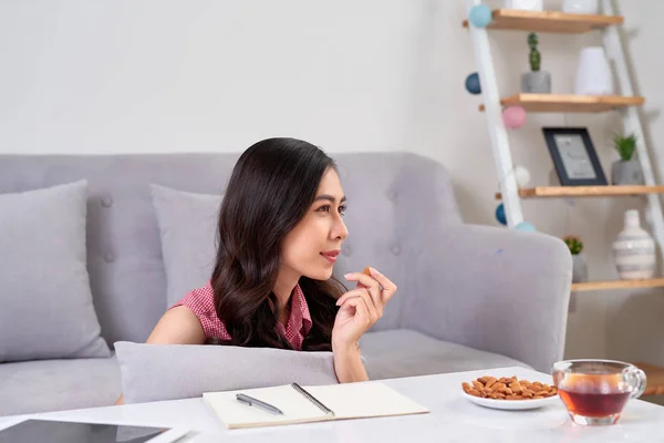 Young Asian Woman Enjoying Tea Break Snack While Working Home — Stock Photo, Image