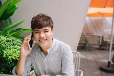 Genç yakışıklı işadamı kafede kapalı telefon görüşmesi yapma