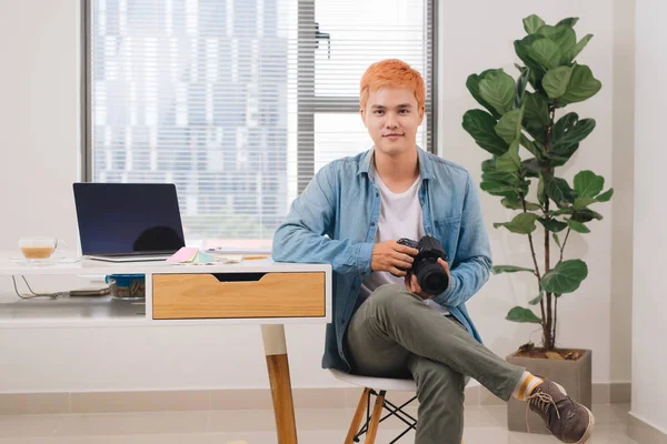 近代的なオフィスのデスクで男性カメラマン — ストック写真