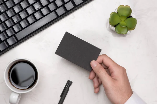 Mockup of black business card in male hand