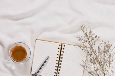 Minimal tarz düz tablo açık defter, kruvasan ve çay ile yatıyordu.