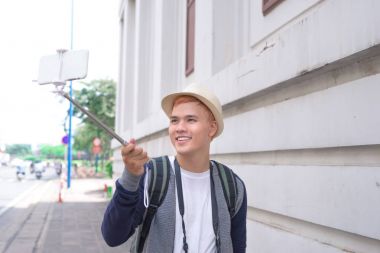 Asya genç adam selfie bir sopa ile yapma