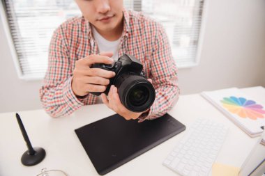 Kameraya bakarak onun masada oturan erkek fotoğrafçı