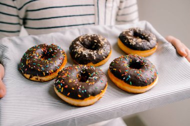 Beyaz zemin üzerine çikolatalı çörek kutusuyla holding erkek eller