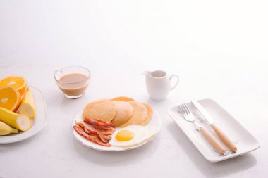 Krep, yumurta, pastırma ve meyve ile kahvaltı tabağı.