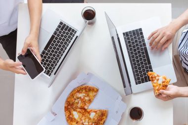 İnsanlar hızlı yemek yemek. Ofiste pizza yemek mutlu iş takım