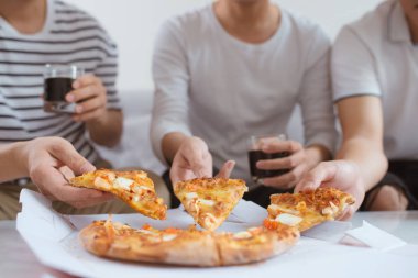 İnsanlar hızlı yemek yeme. Dilim pizza alarak arkadaşlar eller