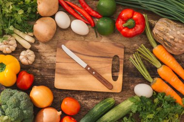 Taze sebze kesme tahtası üzerinde rustik arka plan etrafında. Üstten Görünüm, sağlıklı pişirme kavramı.