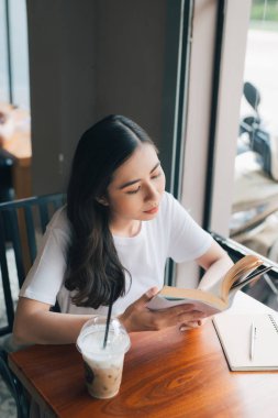 Asyalı kadın okuma kitabı kafe Cafe vintage renk tonu olarak portresi