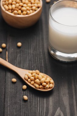 Soya süt ve soya fasulyesi ahşap arka plan üzerinde cam