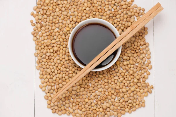 Soy sauce and soy beans on wooden table