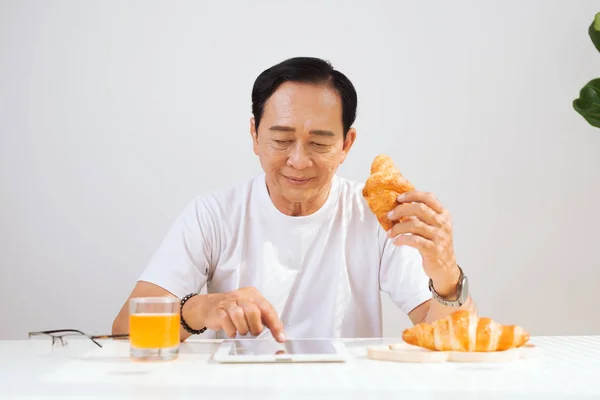 Homem Sênior Feliz Tomando Café Manhã Croissant Casa Bebendo Suco — Fotografia de Stock