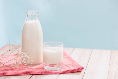 Süt ve süt ürünleri. Şişe süt ve süt ahşap masa üzerinde kırmızı peçete üzerinde