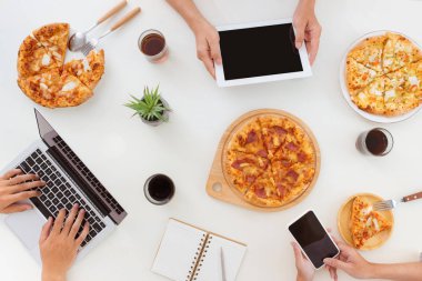 Öğle Yemeği ve insanlar kavramı. Ofiste, üstten görünüm pizza yemek mutlu iş takım