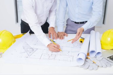 Mimar mühendis mimari proje planı ile masada tartışıyor 