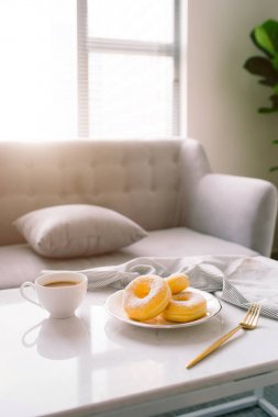 Klasik çörek ve kahve beyaz masada.