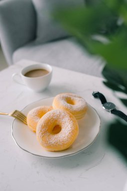 Klasik çörek ve kahve beyaz masada.