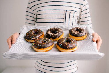 Beyaz zemin üzerine çikolatalı çörek kutusuyla holding erkek eller