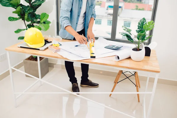 Architect working on drawing table in office