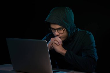 Hacker karanlık bir defter önünde oturan hoody. Bilgisayar gizlilik saldırı