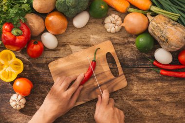 Kırmızı biber kesme. Erkek mutfak pişirme sebze salatası eller. Üstten Görünüm.