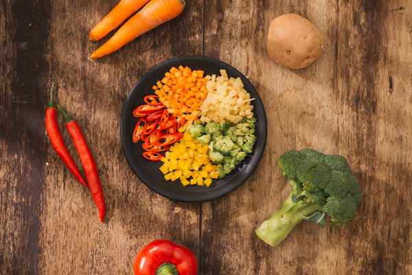 Нарезанные овощи на тарелке и ингредиенты для вкусной вегетарианской кухни. Вид сверху
.