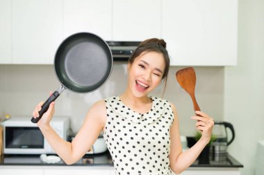 Pan ve mutfak ahşap spatula ayakta tutan mutlu ev kadını