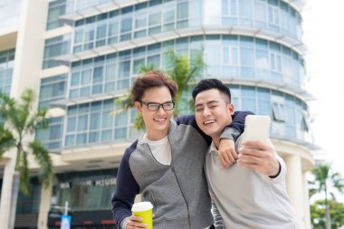 En iyi dostlar. Sarılma ve şehirde yürüyüş iki adam.