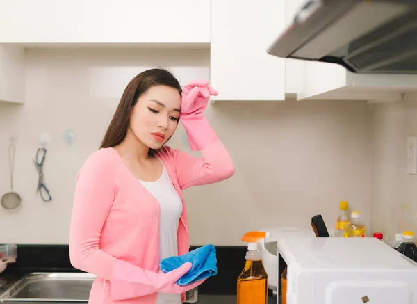 美丽的亚洲妇女在防护手套清洁厨房柜 — 图库照片