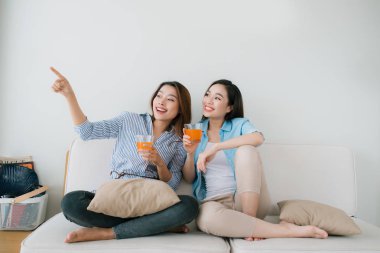 Evde kanepede oturan iki kadın konuşmak ve içme suyu