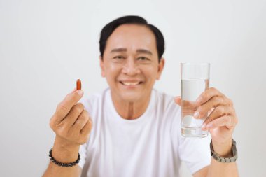 Vitamin ile yaşlı hasta adam / omega 3 elinde.
