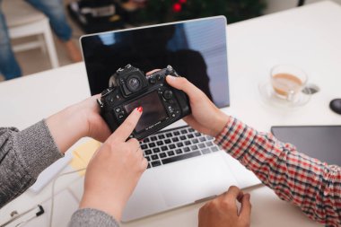 Kamera masada oturan Studio bakarak fotoğraf editörleri