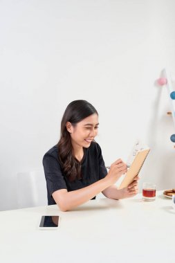 Not Defteri ile masada oturan çalışan oldukça stil sahibi kadın