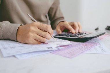 Masa başında oturup hesap makinesini kullanarak mali yapan erkek el, yakın çekim