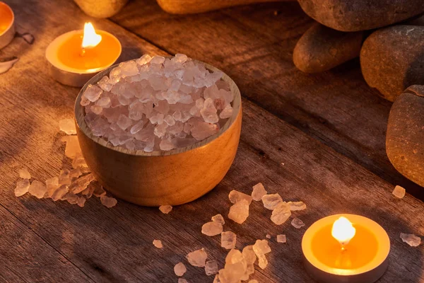 Spa accessories. Body salt in wooden bowl with stones and candles