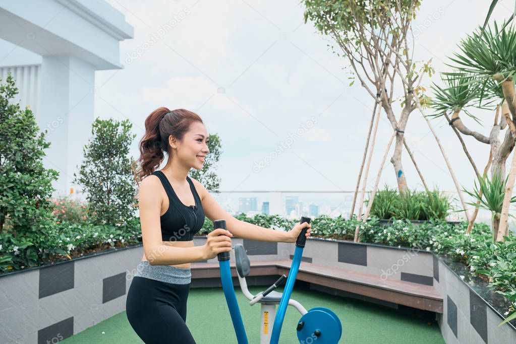 Asian woman exercising at outdoors gym playground 