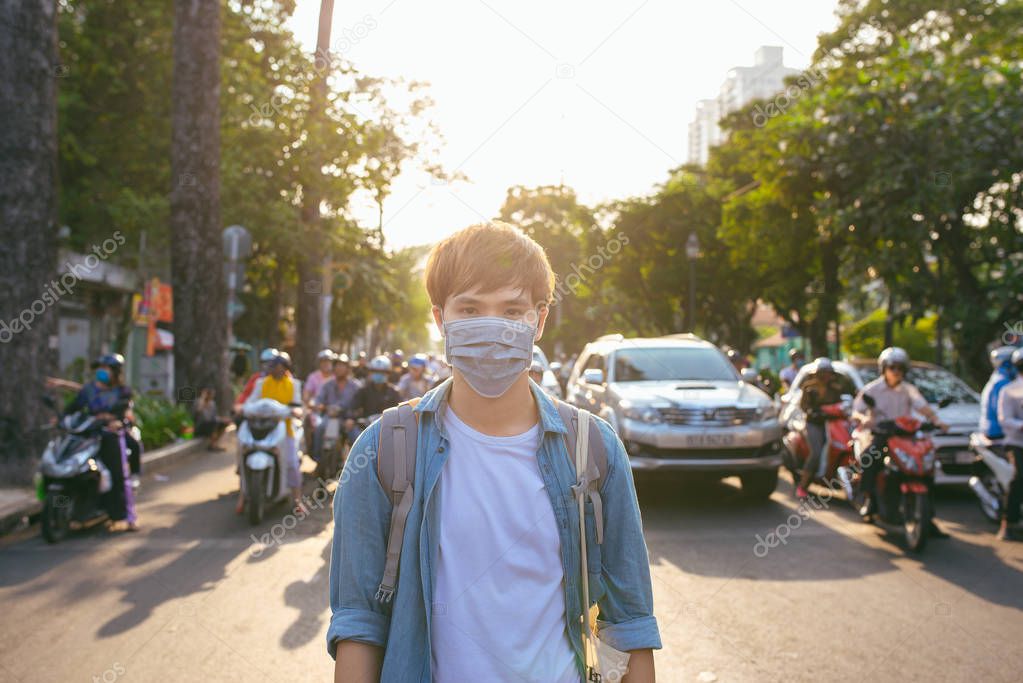 Asian man in street wearing protective mask
