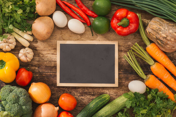 Various fresh vegetables on a wooden table. Top view.