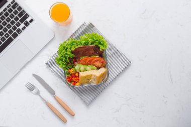 Gıda ofiste. Taze salata ve portakal suyu, üstten görünüm ile çalışmaları için sağlıklı Öğle Yemeği