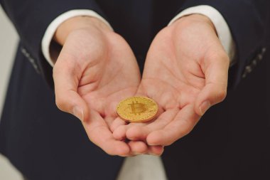 erkek altın bitcoin iki elinde tutan eller. Yakın çekim