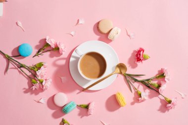 Sabah kahvaltı rahat. Renk macaroons, çiçek ve pembe bir arka plan üzerinde kahve fincanı