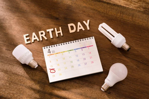 Eco friendly Earth day concept. Saving energy. Calendar on wooden background