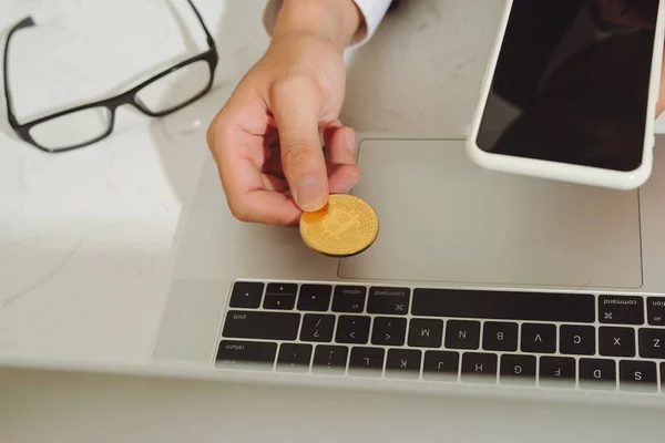 Hand Met Mobilephone Met Bitcoins Met Achtergrond Van Een Laptop — Stockfoto