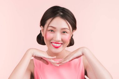 Parlak makyaj ve pembe bir arka plan üzerinde kırmızı dudaklar ile güzel bir kadın portresi.