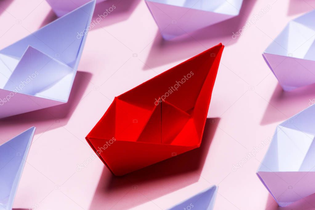 Leadership concept. Red paper ship leading among white