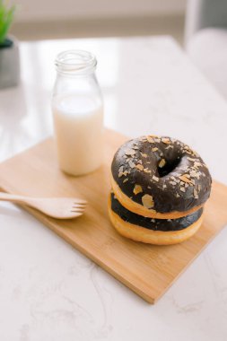 Süt ve donuts ahşap tahta arka plan üzerinde.